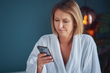 Young Mature woman with phone in bathrobe