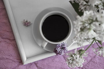 cup of coffee, lilac flower in the apartment