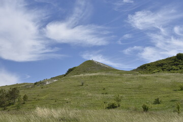 A grassy hillside under a blue sky studded with clouds near Ulyanovsk