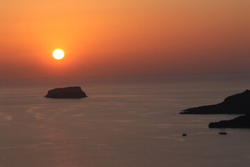 Fototapeta na wymiar Sunset over the Sea of Crete with boats, Santorini, Greece