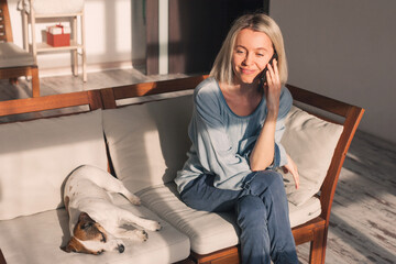 Happy 40s woman talking on mobile phone, making call from home