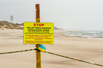 State border between Lithuania and the Russian enclave of Kaliningrad in Russia closed due to sanctions imposed by the EU with stop sign and Ukrainian flag on the beach and watchtower and Baltic Sea - obrazy, fototapety, plakaty
