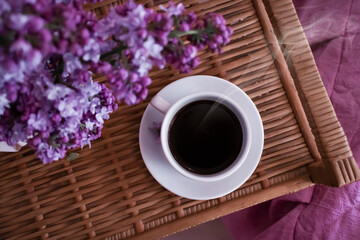 cup of coffee, lilac flower in the apartment