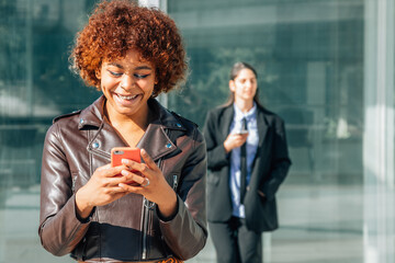 urban african american girl with mobile phone in the street
