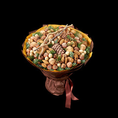 Large bouquet of nuts of different kinds, decorated with twigs of fir and cones on a black background