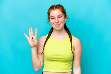 Young reddish woman isolated on blue background happy and counting four with fingers