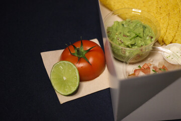 Mexican food, guacamole, chilli, nachos, cheddar, sour cream, tacos, lettuce, avocado, tomato salad, burritos wrap tortilla lime salsa coriander catus capsicum chili pepper onion takeaway delivery box