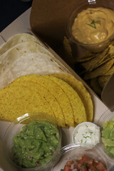 Mexican food, guacamole, chilli, nachos, cheddar, sour cream, tacos, lettuce, avocado, tomato salad, burritos wrap tortilla lime salsa coriander catus capsicum chili pepper onion takeaway delivery box