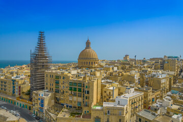 Fototapeta na wymiar Aerial view of Basilica Lady of Mount Carmel church, St. Paul's Cathedral in the old town of Valetta, Malta. Roofs of Malta capital from above on a sunny day