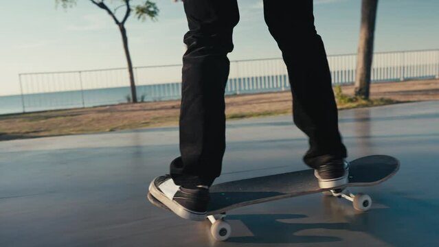 Skateboarding on Street. Cinematic close up of authentic and trendy skateboarder stroll through sunset filled california vibes promenade on warm summer evening. Outdoors activity