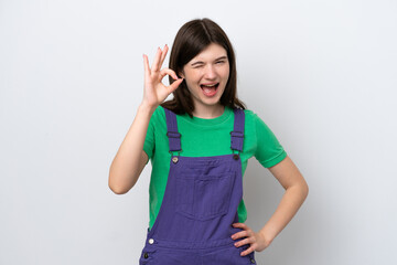 Young Russian woman isolated on blue background showing ok sign with fingers