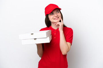 Young Russian pizza delivery picking up pizza boxes isolated on white background thinking an idea...
