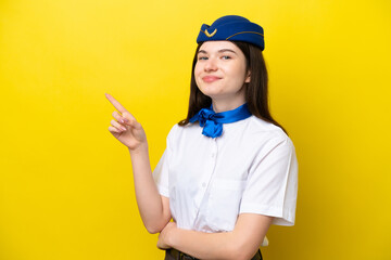 Airplane stewardess Russian woman isolated on yellow background pointing finger to the side