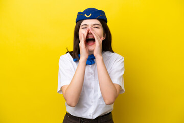 Airplane stewardess Russian woman isolated on yellow background shouting and announcing something