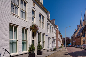 Beautiful perspective line of an old facade houses on a quiet empty street in a bright sunny summer day