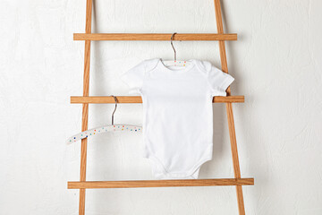Fototapeta na wymiar Mockup of white infant bodysuit made of organic cotton with eco friendly baby accessories. Onesie template for brand, logo, advertising. Flat lay, top view