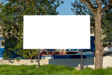 Advertising billboard mock-up in front of construction site, next to trees