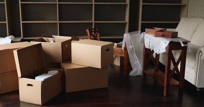 Modern unfurnished living room heap of cardboard boxes full of personal belongings. Concept of professional repairs company, remodelling, tenancy, dwelling for rent, affordable house, bank mortgage