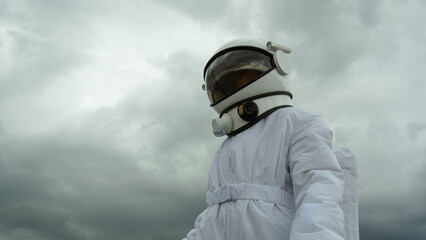 An astronaut explores an unknown planet. Heavy cloudy sky. © yuriyzhuravov