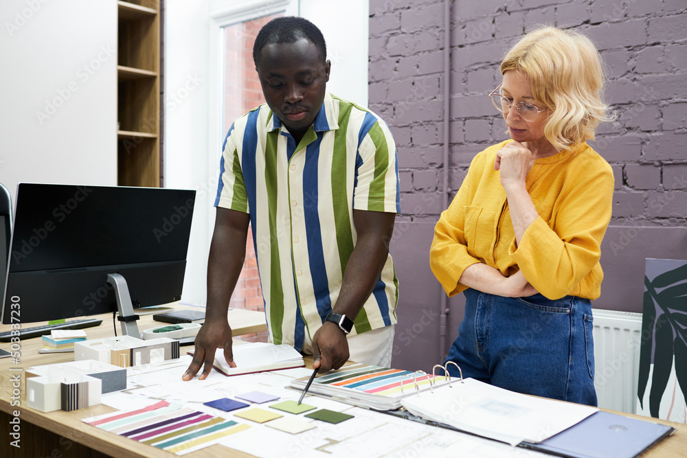 Aufkleber two designers choosing colour in palette at table and discussing new interior during teamwork at mee