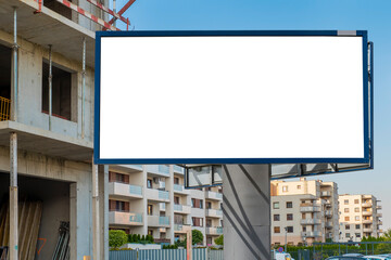 Blank white advertising billboard in front of the building under construction