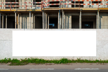 Blank white advertising billboard in front of the building under construction © diesirae