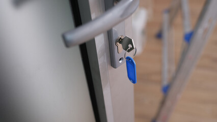 Gray door with steel lock and keys closeup