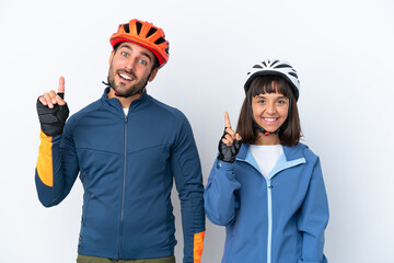 Young cyclist couple isolated on white background showing and lifting a finger in sign of the best