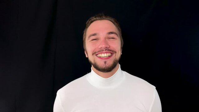 Man in white polo expressing happiness and joy, beautiful white beaming smile