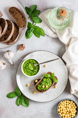 Appetizing bruschetta made from rye bread, pesto and chickpeas on a plate. Top and vertical view