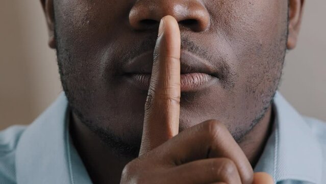 Mysterious unknown male face part african american adult man put finger to lips ask be quiet make gesture silence show secrecy sign keep secret confident information silent forbid tell close up view