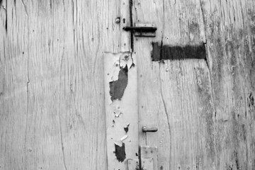 Alte Holztür mit Riegel, Beschlägen und abblätternder Farbe in Knokke-Heist an der Nordsee bei...