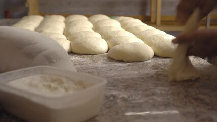 Men's hands hold dough. making raw dough for pizza, rolls or bread. Handmade. Wheat pastries in bakery products. Production of bakery products. Men's hands knead dough. protven or countertop.