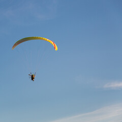 The pilot took off into the sky on an individual backpack parajet with a gasoline engine. Flying with a motorized wing. Extreme sports. Paraglider and small aircraft.