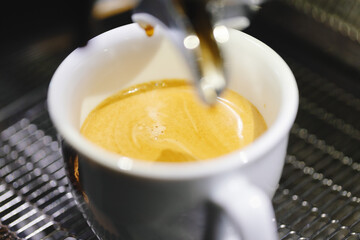 Pouring espresso in cup from machine