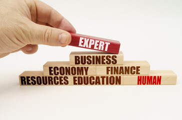 On a white background, the hand adds blocks with inscriptions on a red block, the inscription - EXPERT