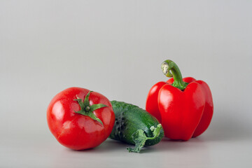 tomato, pepper and cucumber on gray background, selective focus, copy space
