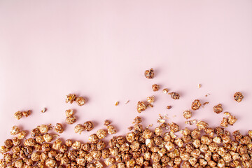 chocolate popcorn on pink background, copy space