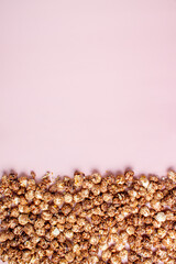 scattering of chocolate popcorn on a pink background, copy space