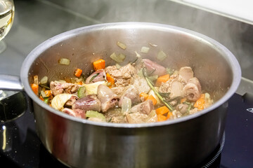 Fried chicken hearts with vegetables on a frying pan