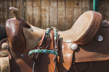 Brown leather saddle and equipment for riding. West style. Decorative bridle, ropes, stirrup....