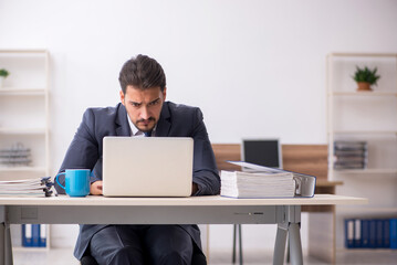 Young male employee sitting at workplace