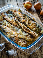 Fish dish - marinated fried herrings on wooden table
