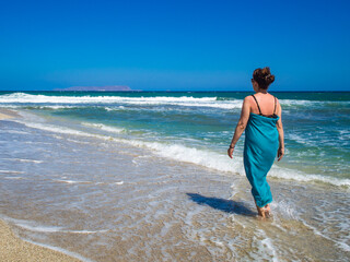 Middle-aged woman walking on beach
