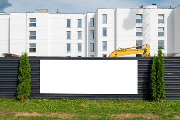 Blank white advertising banner mounted on the fence of construction site