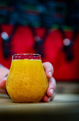man bartender hand hold glass of craft beer stands on a table in a bar or pub