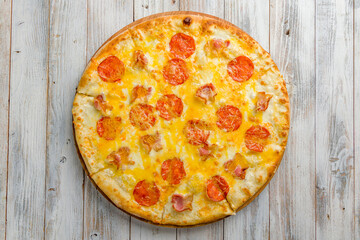 pizza with bacon, pepperoni and cheese top view on white wooden table