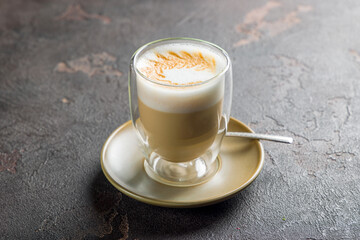 coffee cappuccino with pattern on glass on dark brown table