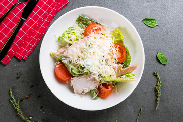 Salad caesar with chicken on white plate on grey table top view