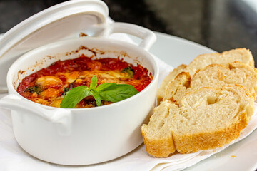 Beef stew with potatoes and carrots in tomato sauce in red pot, gray background. Slow cooking concept